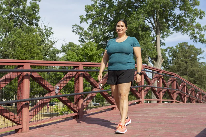 UMass Memorial Medical Center physician, Tara Kumaraswami, walking on a bridge