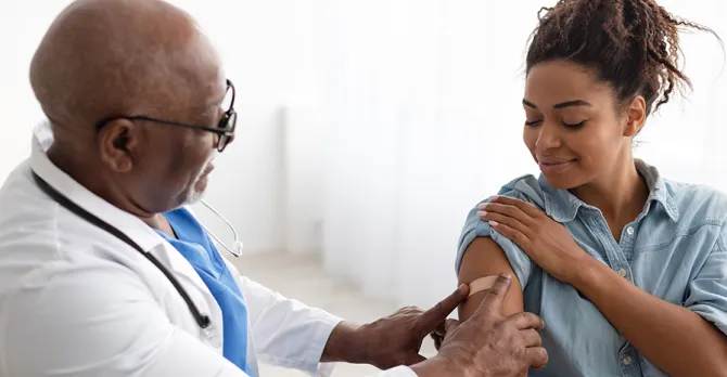 A pregnant woman gets her blood pressure checked in the exam room.