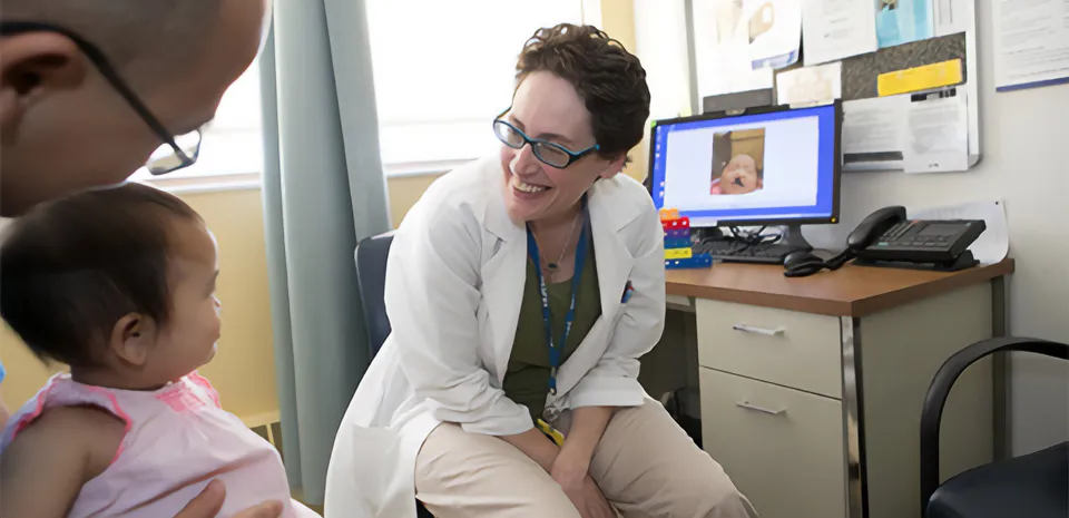 Dr. Janice Lalikos meets with a toddler and her father to discuss surgery.