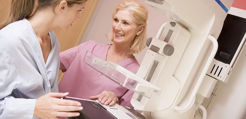 nurse prepping woman for mammogram