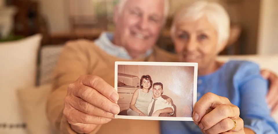 older couple holding a throwback picture together