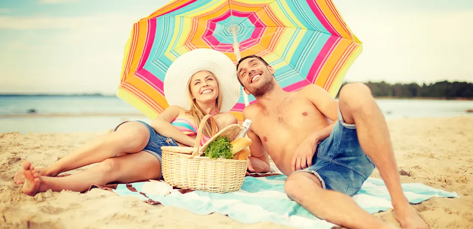 younger couple on the beach under the umbrella