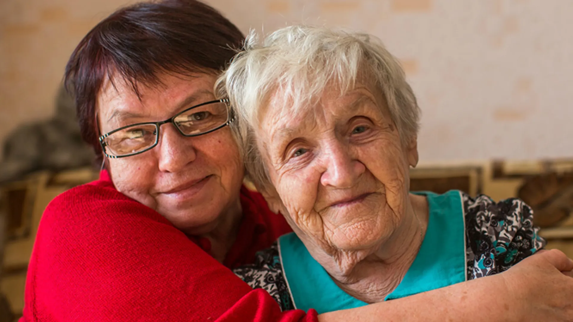 A woman is hugging a mature woman.