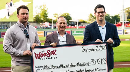 Dr. Larry Rhein, Chair of the Department of Pediatrics, accepting a check from the WooSox Foundation at Polar Park