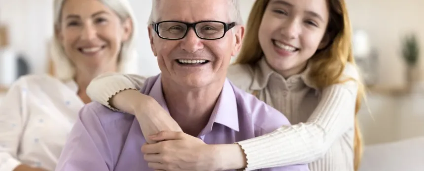 Grandfather with afib being hugged by granddaughter while grandma watches