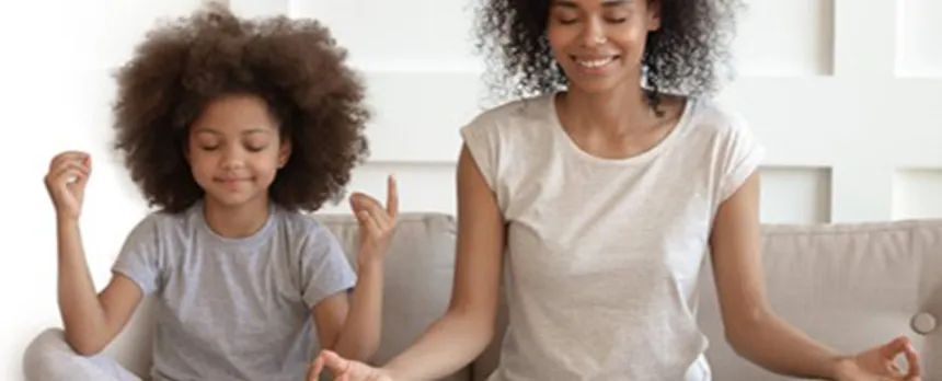 diverse mom and daughter mediating in their living room