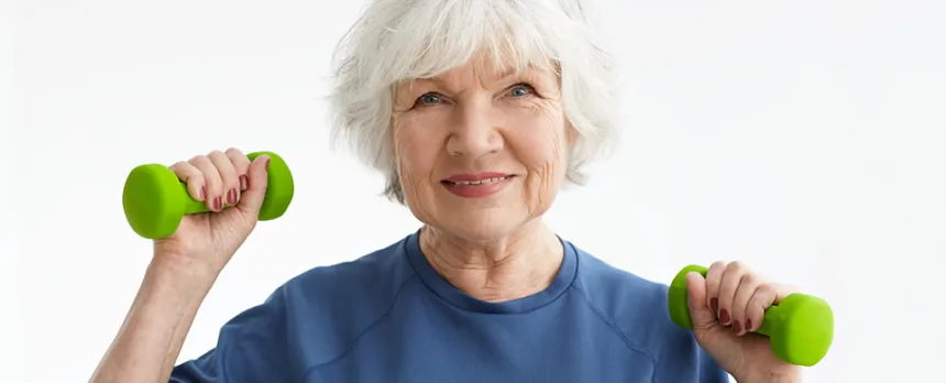 elderly woman lifting dumb bells and exercising