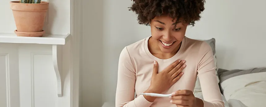 young woman excited and reading pregnancy test