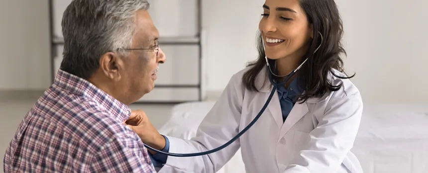 Image of woman doctor with a stethoscope to a patient